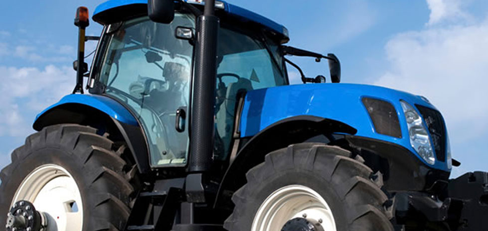 Tractor azul con cielos azules.