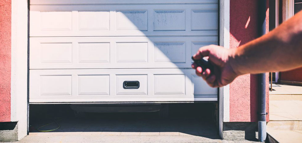 La persona fa clic manualmente sull'apriporta del garage per aprire la porta del garage